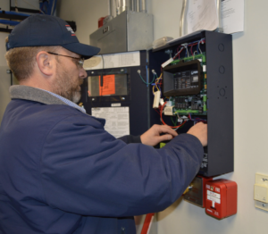 A technician working on a fire alarm system